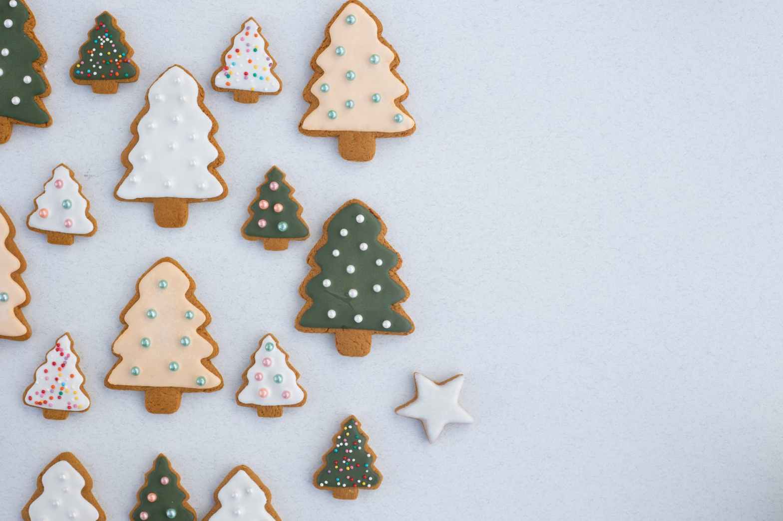 christmas tree shaped cookies with frosting and sprinkles